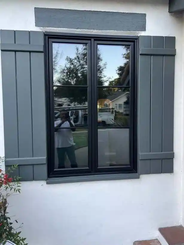 Black double hung windows with shutters